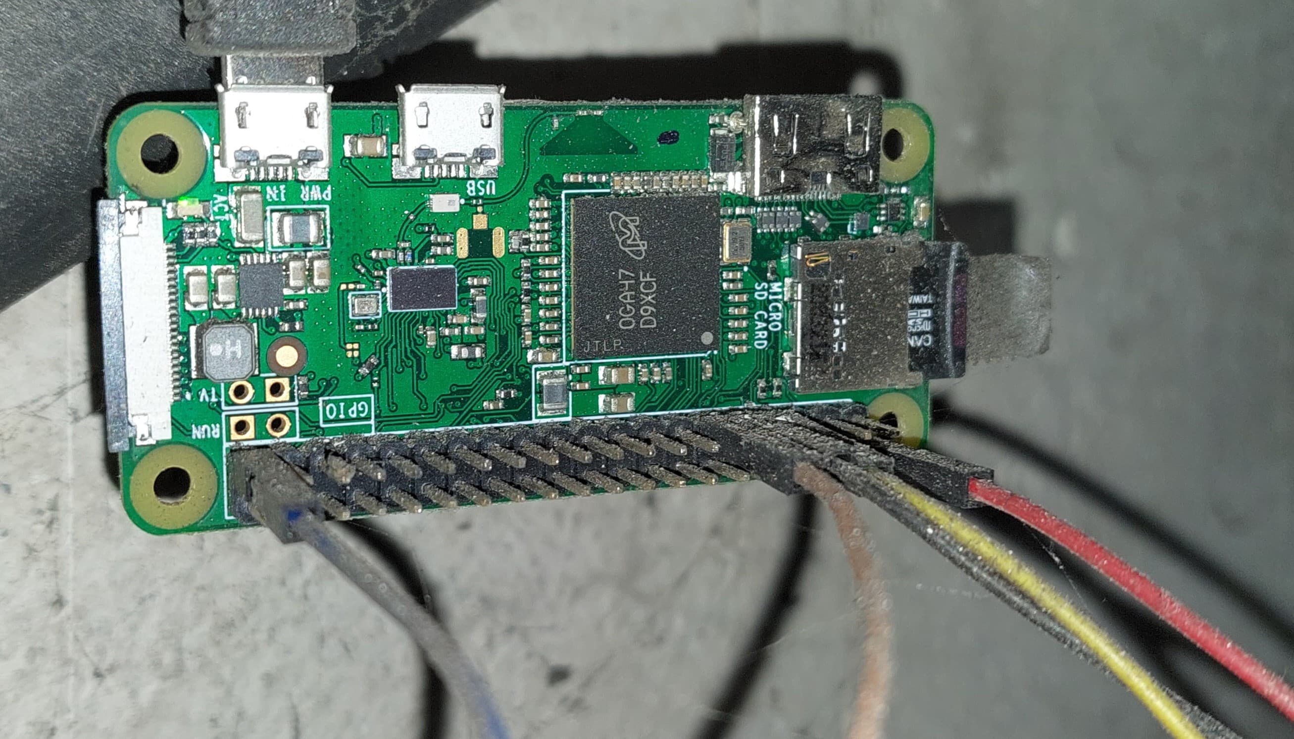 zdjęcie podłączonego Raspberry Pi Zero W wiszącego na ścianie z podłączonymi przewodami do GPIO